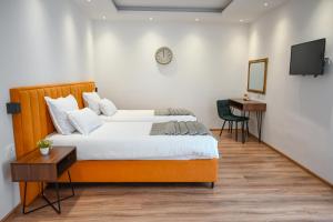 una camera da letto con un letto, una scrivania e una TV di Hotel Premium a Jajce Altre 37 foto