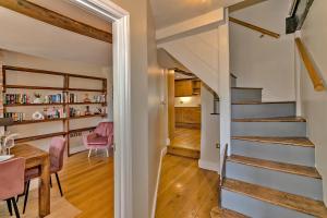 ein Zimmer mit einer Treppe und einem Esszimmer mit einem Tisch in der Unterkunft Finest Retreats - The Old Coach House in Stony Stratford