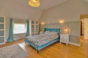 ein Schlafzimmer mit einem blauen Bett und einem Fenster in der Unterkunft Finest Retreats - The Old Coach House in Stony Stratford