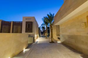 a view of the entrance to a building with a palm tree at Nayah Stays, Ground terraces Studio in Hurghada