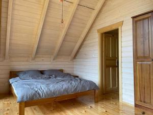 Cama en habitación con techo de madera en Blisko natury - chatka z sauną w Zawoi, en Zawoja