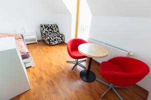a room with two red chairs and a table and a bed at Hájenka Kozlov in Litomyšl +14 photos