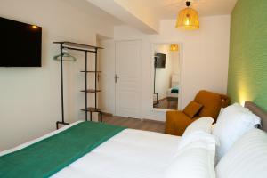 1 dormitorio con cama blanca y pared verde en Les clés de la ferme - 4 chambres - proche La Loupe et Nogent-le-Rotrou - option SPA, en Sablons-sur-Huisne