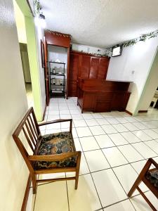 een woonkamer met een stoel en een trap bij E.W.B. Properties in Basseterre