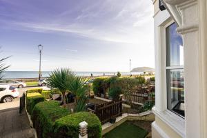 a house with a window looking out at the beach at Can-Y-Bae Hotel in Llandudno