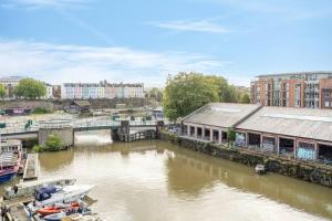 um rio com barcos numa cidade com edifícios em Cosy 2 bed flat in central Bristol on river Avon em Bristol