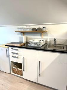 a kitchen with white cabinets and a sink at Cosy berry loft in Rovaniemi