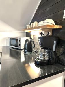 a kitchen counter with a coffee maker and a microwave at Cosy berry loft in Rovaniemi