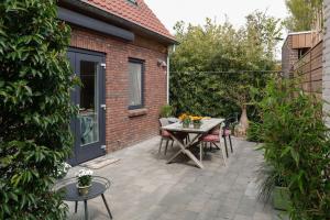 a patio with a table and chairs and a building at Vrijvakantiehuis Duinweg 2b in Oostkapelle
