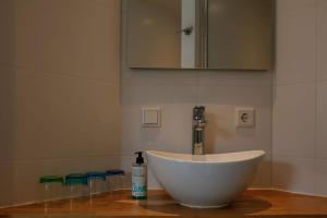 Un lavabo blanco con una botella de jabón sobre una encimera. en Vrijvakantiehuis Duinweg 2b, en Oostkapelle
