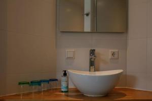 a white bowl sink with a bottle of soap on a counter at Duinweg 2b in Oostkapelle