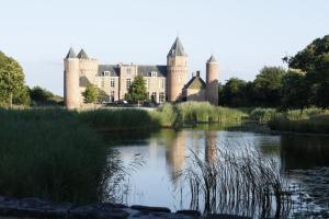 un castillo con un lago frente a él en Vrijvakantiehuis Duinweg 2b, en Oostkapelle