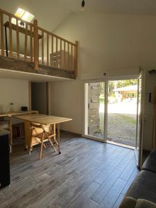 ein Wohnzimmer mit einem Holztisch und einer Treppe in der Unterkunft Eco-gîte en pleine nature in Lisle-sur-Tarn