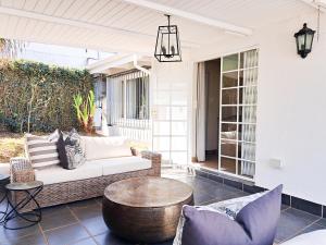 eine Veranda mit einem Sofa und einem Couchtisch in der Unterkunft Thornton Gap Guesthouse in Johannesburg
