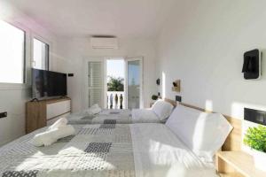 1 dormitorio blanco con 1 cama grande y TV en Villa Sofía Maspalomas en San Bartolomé