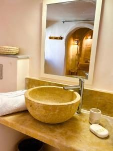 un bagno con un grande lavandino in pietra con specchio di Dar Shams a Hara Srira