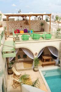 um pátio com uma varanda e uma piscina em Dar Shams em Erriadh