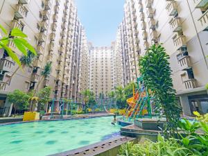 a pool in the middle of a building with a playground at OYO Life 92976 Apartement Jarrdin By Apato in Bandung