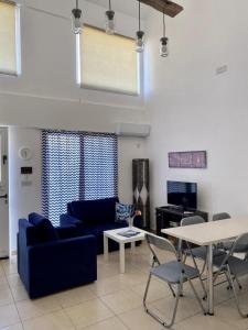 een woonkamer met een blauwe bank en een tafel bij Loft with Garden 4 min to Beach in Kyrenia in Kyrenia