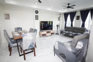 a living room with a table and chairs and a television at Luxurious Place Mountain View Spacious with WIFI Near SM Lucena in Lucena