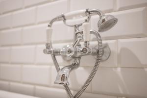 une douche avec pommeau de douche dans une salle de bain dans l'établissement Malarskie Atelier, à Toruń 25 autres photos