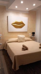 a bedroom with a bed with a goldlip on the wall at Casa Anseramo in Bisceglie
