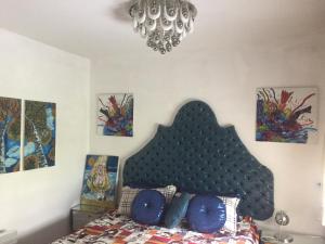um quarto com uma cama com uma cabeceira preta e pinturas em Аpartment Centаr em Skopje