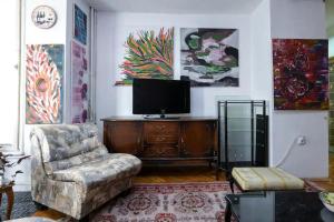 uma sala de estar com uma cadeira e uma televisão de ecrã plano em Аpartment Centаr em Skopje