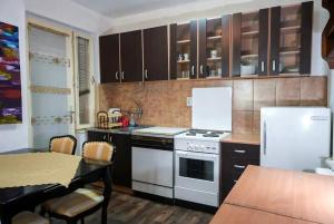 uma cozinha com um fogão branco e um frigorífico branco em Аpartment Centаr em Skopje