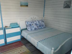 a bedroom with a bed and a nightstand with a white bed sidx sidx sidx at Blue Bungalow Jurilovca in Jurilovca