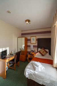 een hotelkamer met een bed en een bureau bij Can-Y-Bae Hotel in Llandudno