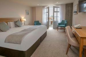 a hotel room with a large bed and a desk at Old Hunstanton Le Strange Arms Hotel in Hunstanton