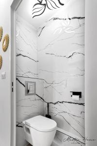 baño con aseo blanco y paredes de mármol en Gout de luxe à Narbonne T3 Climatisé, Spa, Parking, en Narbona