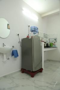 La salle de bains est pourvue d'un évier et d'un réfrigérateur. dans l'établissement Tree shadow Guest house nearby Beach, à Mahabalipuram