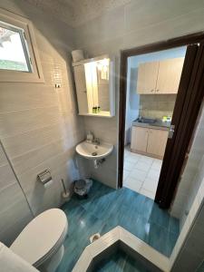 a small bathroom with a toilet and a sink at Villa Panorama Studios in Possidi