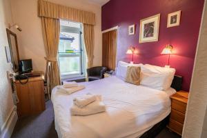 una habitación de hotel con una cama grande con toallas. en Can-Y-Bae Hotel en Llandudno