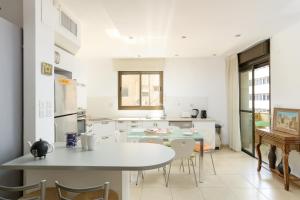 eine Küche und ein Esszimmer mit einem Tisch und Stühlen in der Unterkunft Cosy 1BR near Beach by FeelHome in Tel Aviv