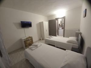 ein Hotelzimmer mit drei Betten und einem Fernseher in der Unterkunft Residenze Amelia in Parma + 2 Fotos