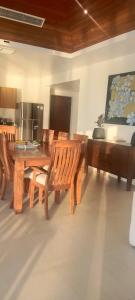 a dining room with a wooden table and chairs at Baan Tasha in Laem Sor
