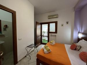 1 dormitorio con 2 camas y ventana en Glicine room Sperlongaresort, en Sperlonga