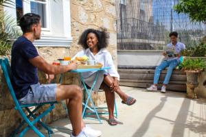 a man and woman sitting at a table eating food at B&B Villa Du Roc Fleuri in Cannes