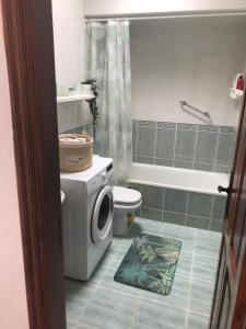uma casa de banho com um WC e uma máquina de lavar roupa em One bedroom bungalow Playa Bastian Costa Teguise em Costa Teguise