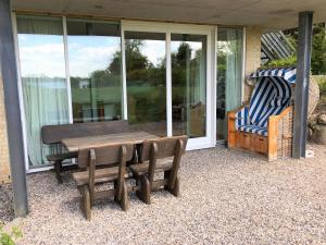 a patio with a wooden table and chairs on a house at Ferienwohnung Schleistrand in Kappeln