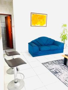 Carvalho de Muriqui في مانغاراتيبا: غرفة معيشة مع أريكة زرقاء وكرسي