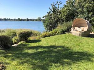 a boat sitting on the grass next to a lake at Ferienwohnung Schleistrand in Kappeln