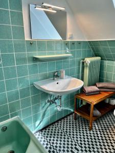 uma casa de banho com um lavatório, uma banheira e um espelho. em Fischerklause am Lutjensee em Lütjensee