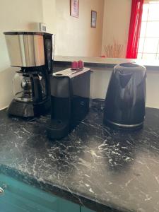 uma bancada preta com uma máquina de café em TICOMBAVA à la Possession em La Possession