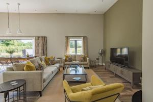 a living room with a couch and a tv at The Old Cherry Barn - Luxury barn conversion in Faversham