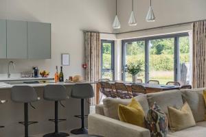 a kitchen and living room with a couch and a table at The Old Cherry Barn - Luxury barn conversion in Faversham