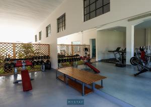 a room with a gym with a bench and bikes at Hotel Lena Village in Mortágua